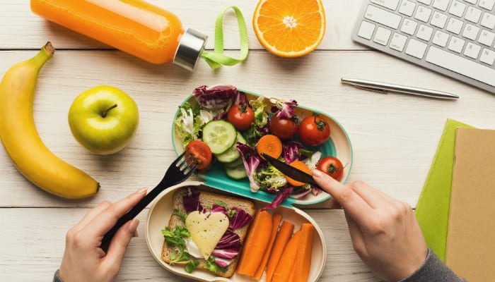 Employee eating healthy food at healthy workplace